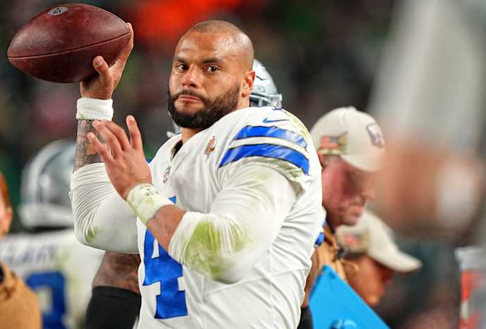 Dak prescott holds the ball with one hand preparing to throw